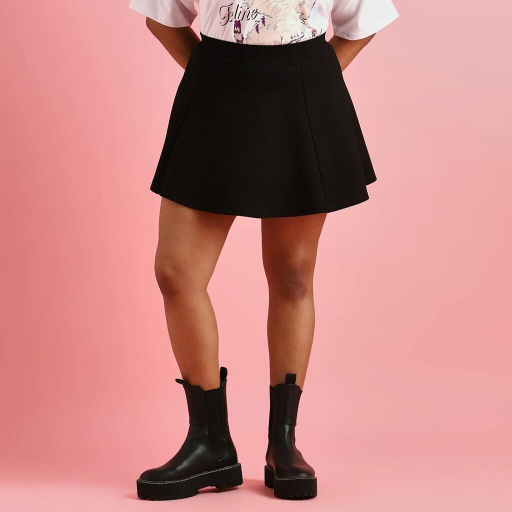 fashionable black skirt and boots on pink background