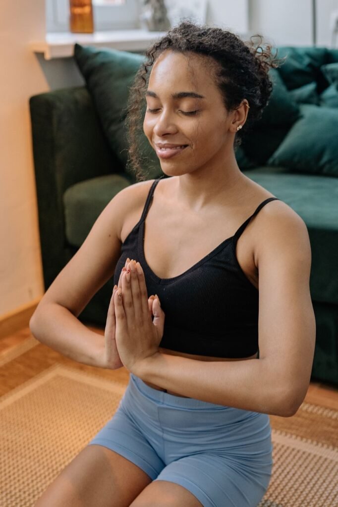 woman in tank top and blue shorts meditating