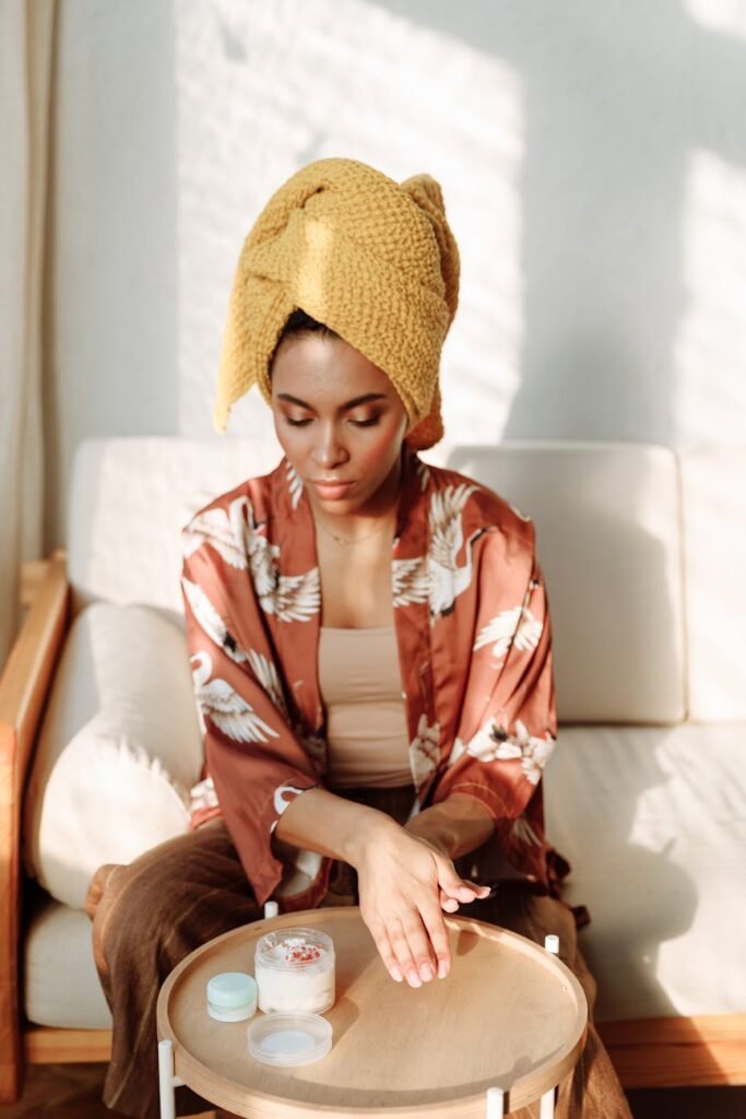 woman with head towel applying lotion on her hand